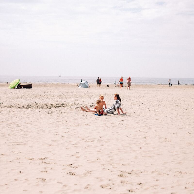 Strand in Nederland met enkele mensen op de voorgrond