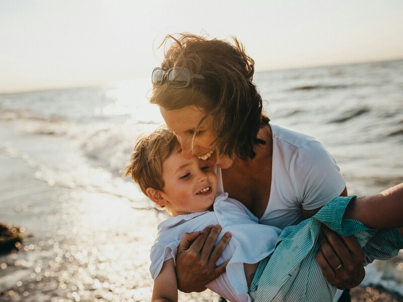 Mother holding her son at the beach
